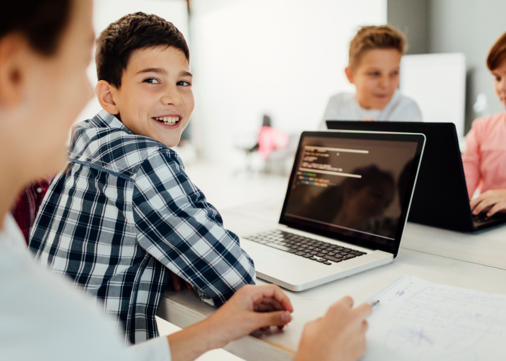 boy sitting at a computer trying code